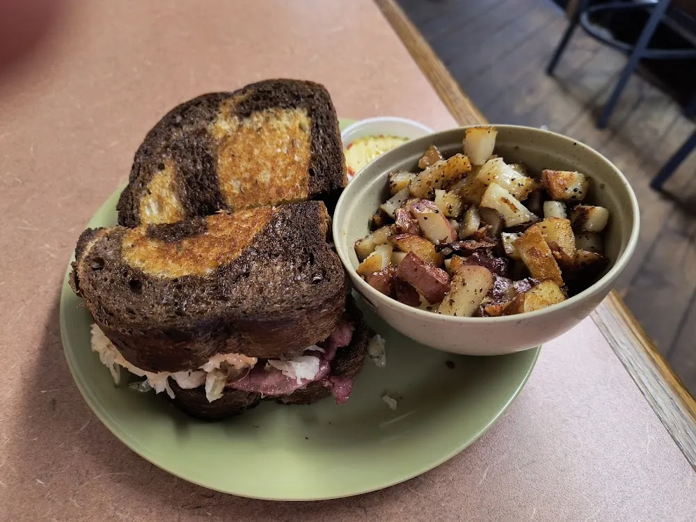 Grilled Reuben Sandwich on Toasted Marble Rye with Seasoned Potatoes